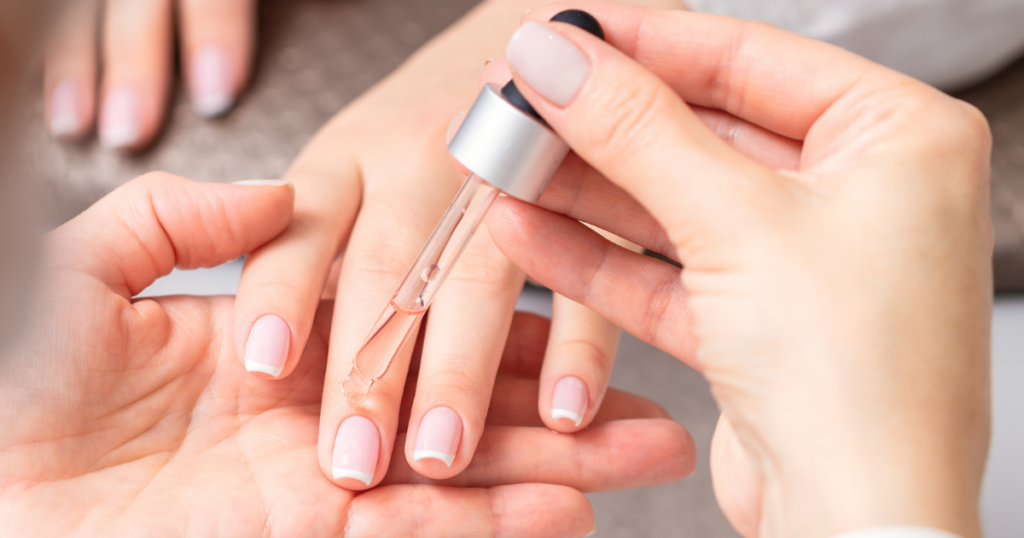 Image of cuticle oil being applied with a dropper, as part of a cuticle care routine