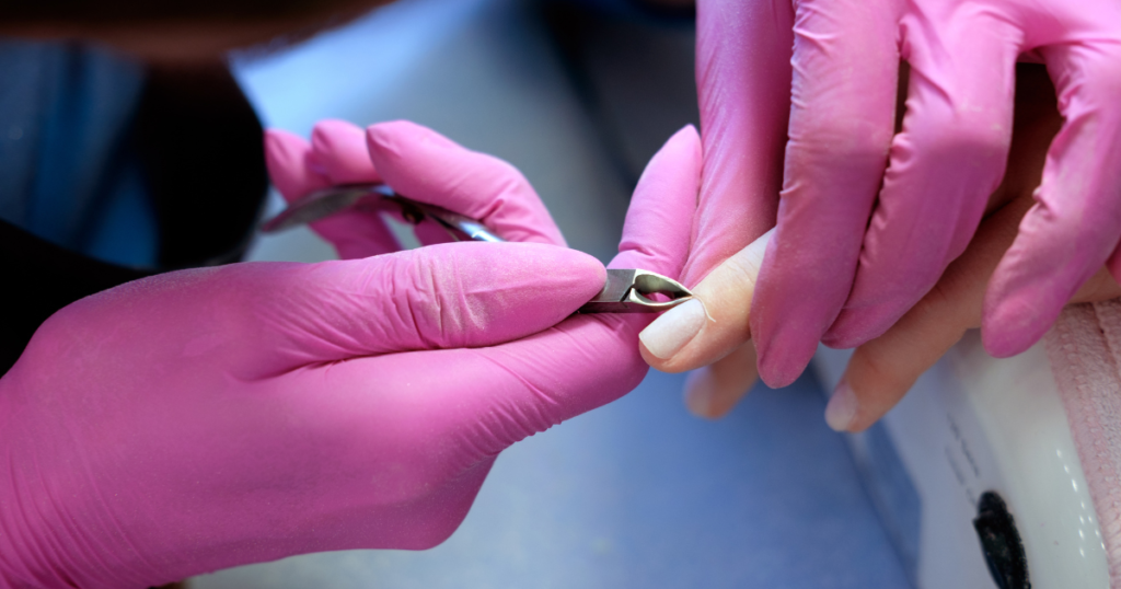 Image of a professional nail tech cutting cuticles